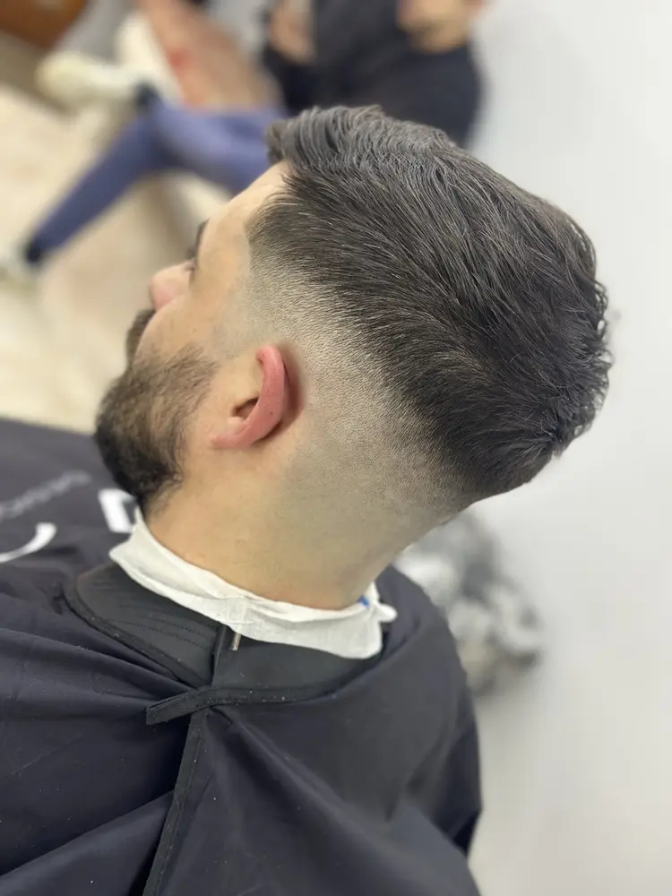 Corte degradado con barba, visto de perfil