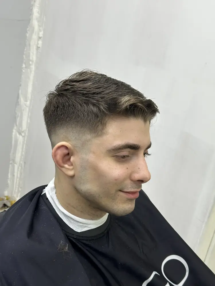 Cliente sonriendo con su corte degradado terminado