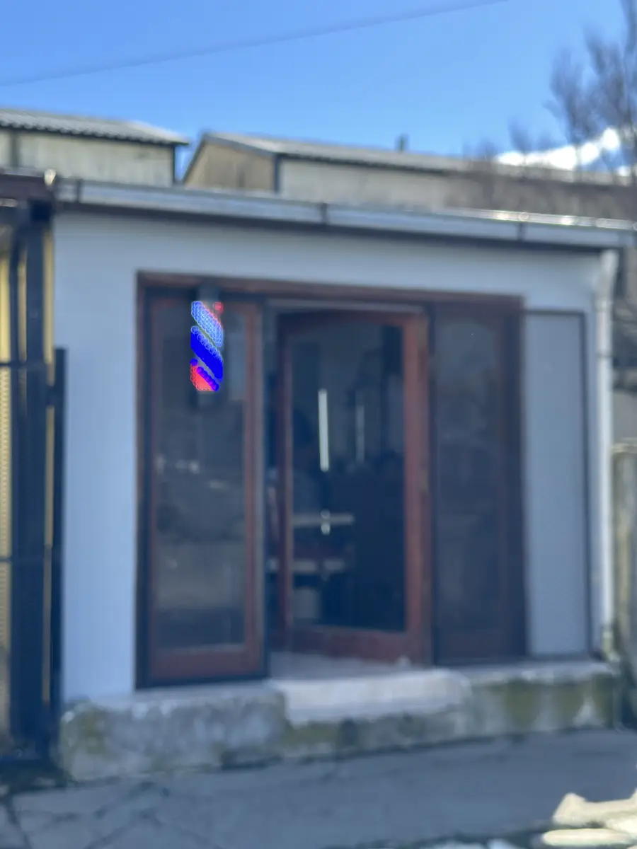 La fachada de la barbería con el poste de barbero